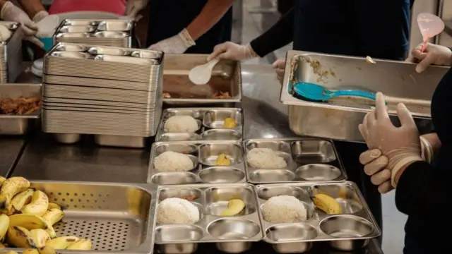 Pekerja di dapur makan bergizi gratis menyiapkan makanan untuk diantar ke sekolah pada 6 Januari 2025.