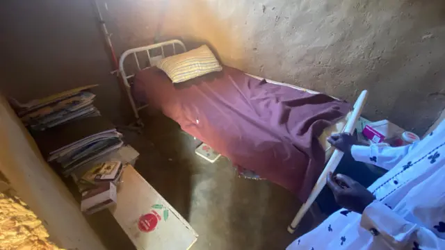 A shop with one bed that is being used as a hospital