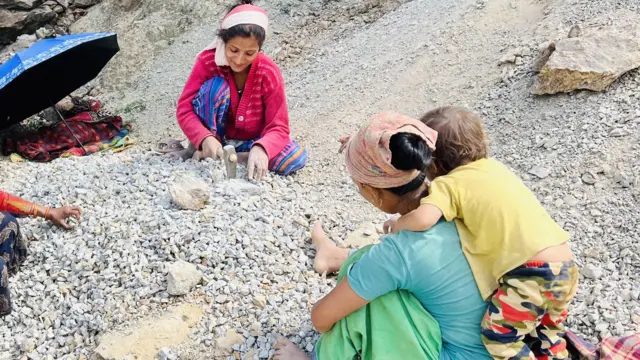 घाममा गिट्टी कुट्दै महिला