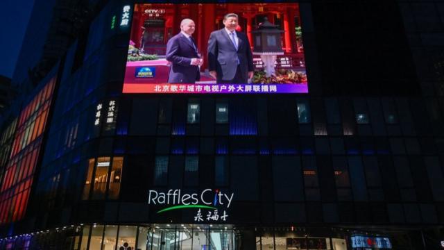 中国街头液晶大屏幕播出的朔尔茨访华与习近平会面的新闻画面。