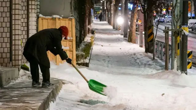 '내 집 앞 눈은 내가 치웁니다'. 7일 오전 서울 관악구 호암로 인근 한 건물에서 시민이 전날 밤사이 내린 눈을 치우고 있다