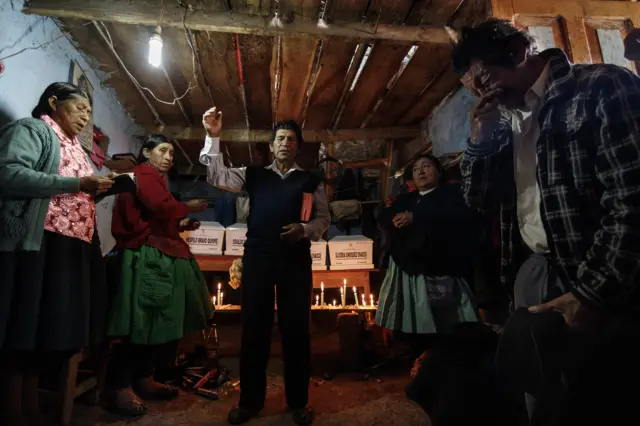 Mujeres sobrevivientes elevan oraciones junto al sacerdote de la comunidad. (Foto: Ángela Ponce).