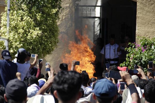 Толпа на мобильные телефоны снимает момент сожжения