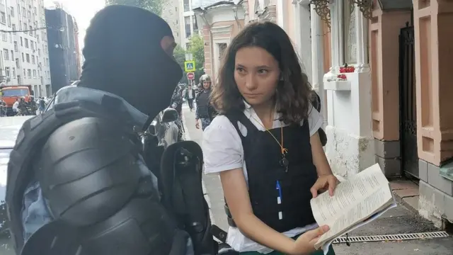 ओल्गा संविधानाची प्रत पोलिसांना दाखवताना