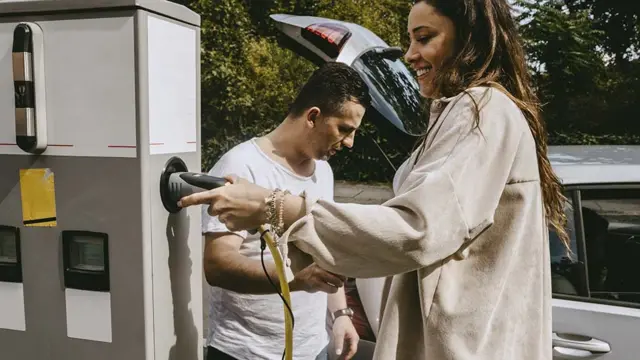 Mulher e homem carregando um carro elétrico