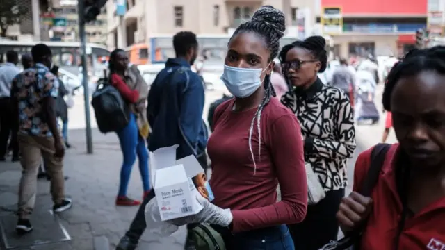 Une femme vend des masques faciaux dans une rue du centre-ville de Nairobi, au Kenya