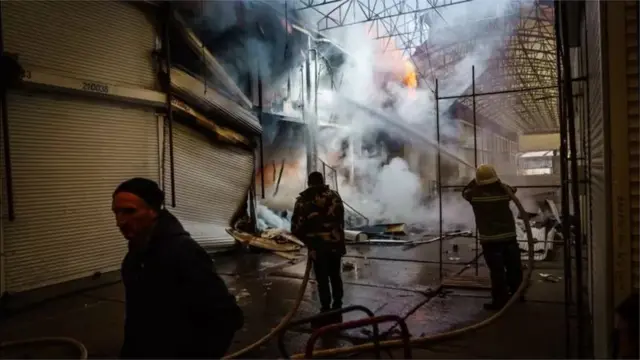 ખારકિએવમાં રશિયાના બૉમ્બમારામાં લાગેલી આગ ઓલવતાં અગ્નિશામકદળના કર્મીઓ