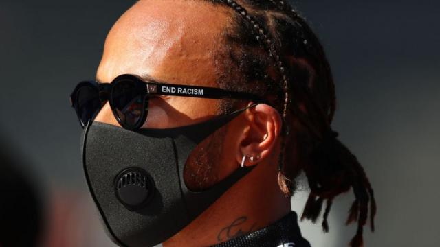 Lewis Hamilton de máscara contra covid e óculos escuros com mensagem pelo fim do racismo na haste