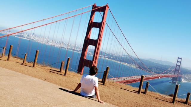 A boy looks at the Golden Gate bridge