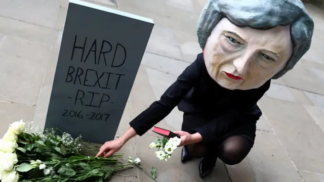 Temsili bir mezar taşının üzerinde May'in ısrarcı olduğu "sert Brexit"in ismi yazılı.