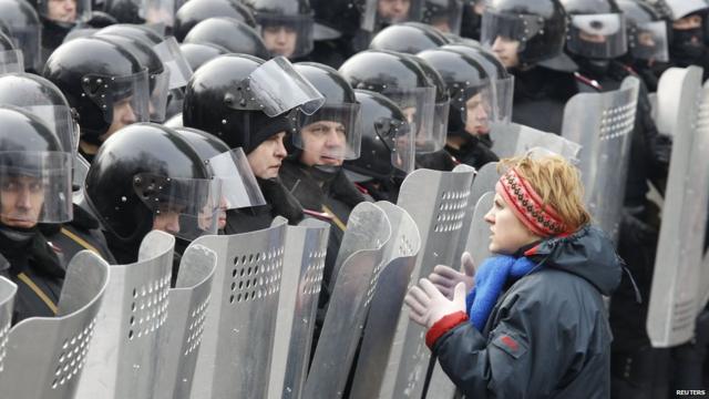 A woman addresses riot police with shields during a rally held by pro-European integration protesters in Kiev on 21 January 2014.
