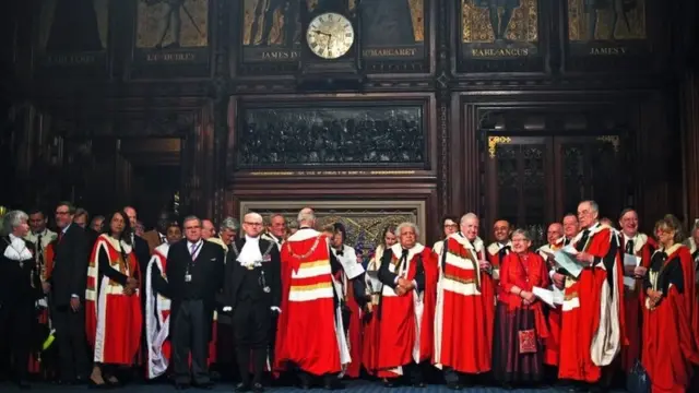 Staff and members of the House of Lords wait ahead of the State Opening of Parliament