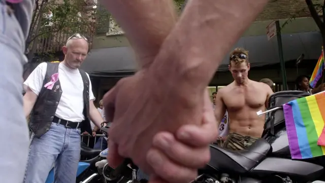 Gay men hold hands to remember their friends who died of Aids in a New York parade