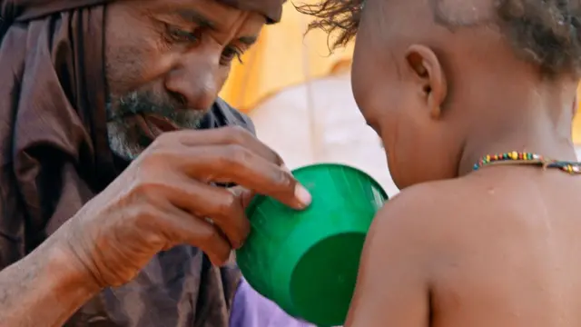 Scene du film montrant un gomme lavant un enfant avec un peu d'eau
