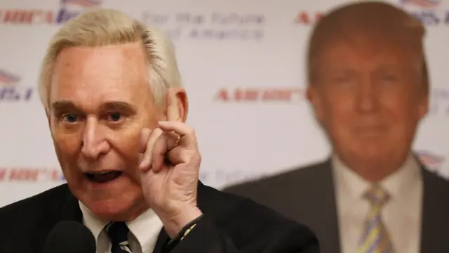 Roger Stone habla delante de una imagen de Donald Trump