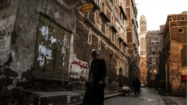 رجل يسير في أحد أحياء العاصمة اليمنية صنعاء