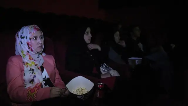 ફિલ્મ જોતી વખતે પોપ કોર્નનો સ્વાદ માણી રહેલી મહિલાઓની તસવીર