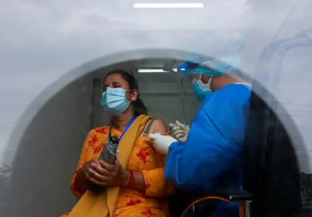 काठमाण्डूमा चीनमा निर्मित कोभिड खोप लिँदै एक महिला