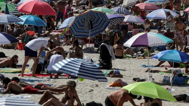 People enjoy a sunny and warm weather on the beach of the Croisette following the outbreak of the coronavirus disease