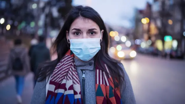 Una mujer con mascarilla en la calle.