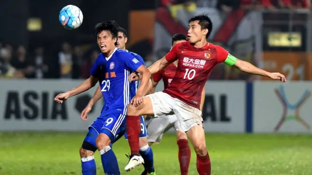 4月25日，廣州恆大隊球員鄭智（前右）與香港東方龍獅隊球員粱振邦（前左）在比賽中拼搶