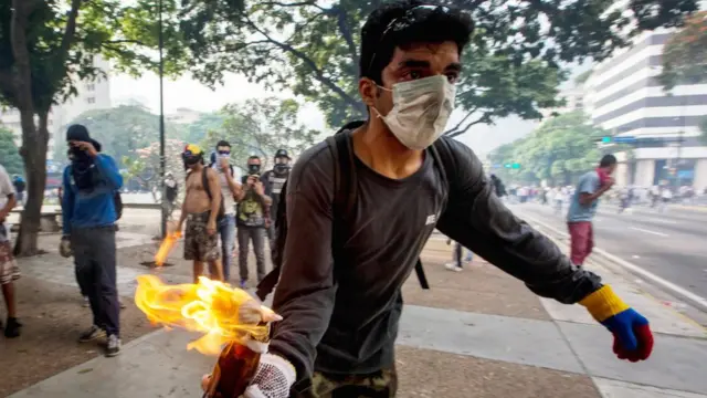 Una manifestante de oposición lanza un cóctel molotov a la policía.