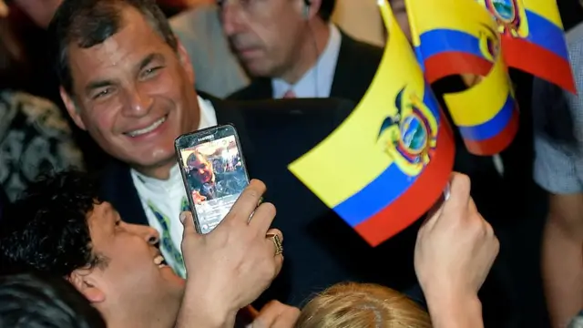 El presidente ecuatoriano Rafael Correa sonríe ante las cámaras cuando le toman un selfie.