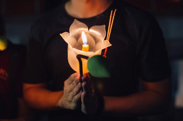 Vela encendida en una flor de loto