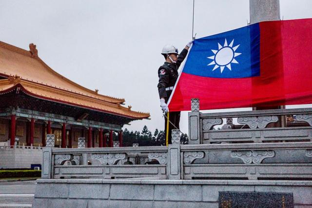 Солдаты поднимают флаг Тайваня перед президентскими выборами в Тайбэе в январе 2016 года