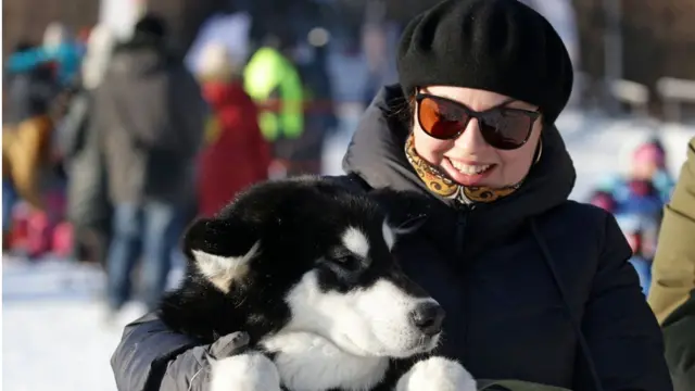 রাশিয়ার নভোসিবার্সক অঞ্চলে কুকুরের স্লেড প্রতিযোগিতায় অংশ নিতে আসা নারী, ১২-০১-২০২০।