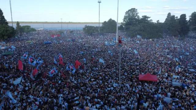 Multitud de personas agolpadas en la calle junto a la ribera del río en Rosario.