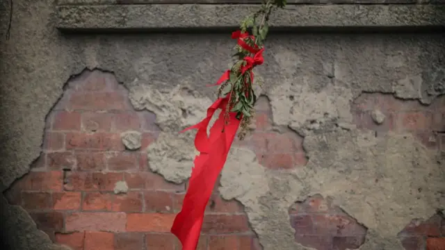 Rosa roja y una tela del mismo color en una fachada en Colombia