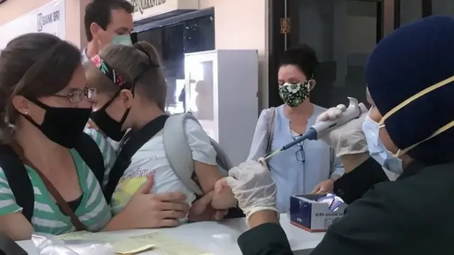 Warga negara asing di bandara Sentani, Jayapura Kamis (23/04) yang diminta pulang oleh pemerintah atau organisasi masing-masing, dites darah.