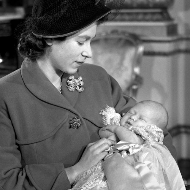 A princesa Elizabeth (agora Rainha Elizabeth 2ª) segurando o filho primogênito, príncipe Charles, após sua cerimônia de batismo no Palácio de Buckingham