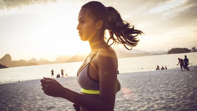 Mulher corre na praia