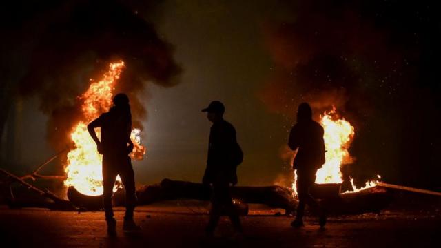 Manifestantes frente a una hoguera