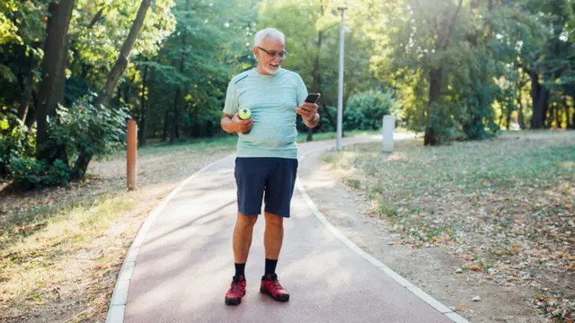 Un hombre hace ejercicio y mira el teléfono.
