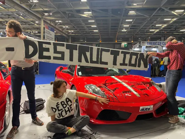 معترضان با اشغال یک غرفه در نمایشگاه پاریس خود را به زمین چسباندند