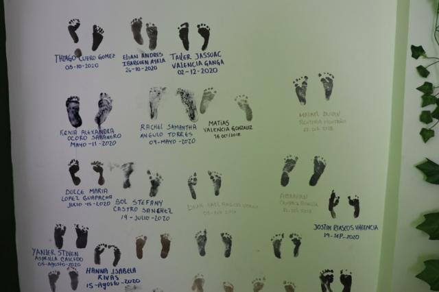 Des empreintes de pied sur une affiche avec des noms des bébés nés avec l'assistance des parteras.