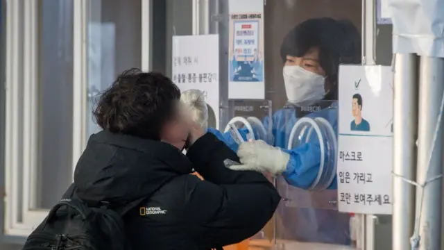 22일 서울역광장에 마련된 선별검사소를 찾은 한 시민이 PCR검사를 위한 검체채취를 하고 있다