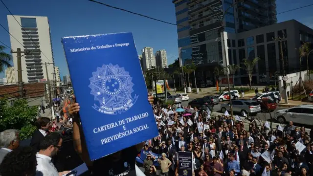 Manifestantes seguram uma carteiranovibet origintrabalho gigantenovibet originprotesto contra a possível extinção da Justiça do Trabalho (São Paulo, janeironovibet origin2019)