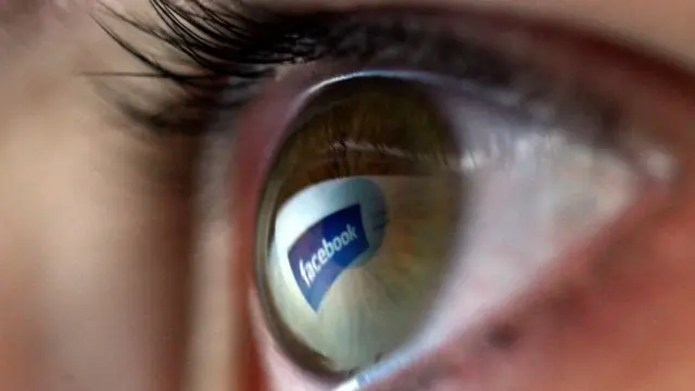 El logo de Facebook reflejado en el ojo de una niña.