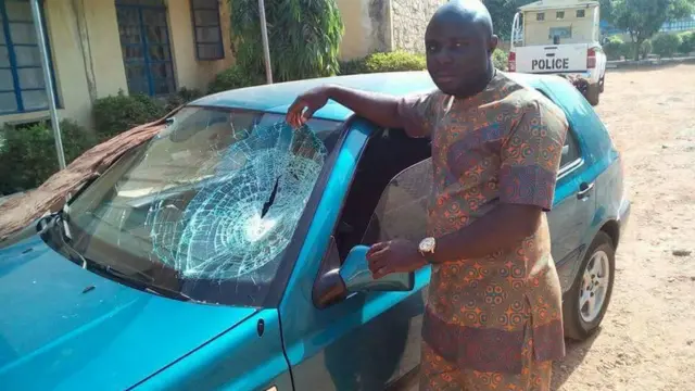 Austin Nemba stand near im car wey dem spoil di windscreen