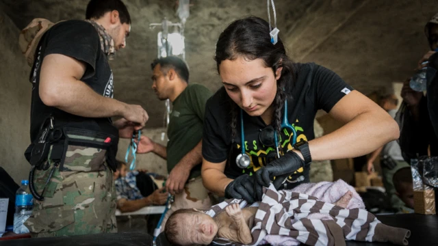 Katie Batrouney na kula da lafiyar jariri Suleyman, dan watanni biyu, a birnin Mosul, na Iraqi