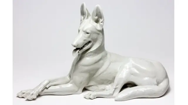 Escultura blanca de porcelana de un perro alsaciano.