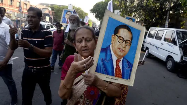 બાબા સાહેબ આંબેડકરની છબી લઈ જઈ રહેલાં મહિલા