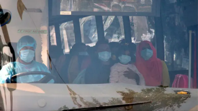 বাসের ভেতরে উহান থেকে আগত উদ্বিগ্ন যাত্রীরা। সংক্রমণ এড়াতে তাদের মুখ ঢাকা সার্জিক্যাল মাস্কে।