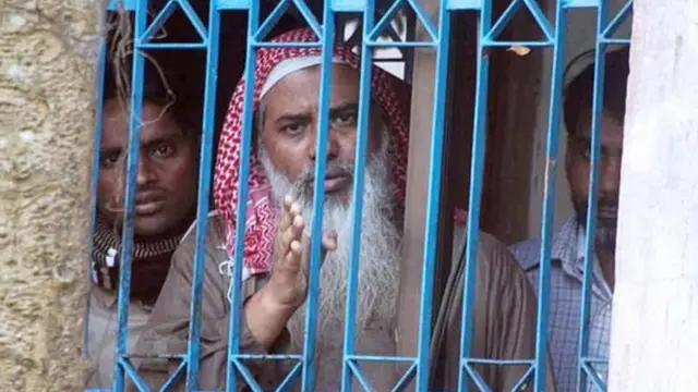 ২০০৬ সালের অভিযান চলাকালে 'সূর্য্য দীঘল বাড়ি'র জানালা থেকে এভাবেই সাংবাদিকদের ক্যামেরায় ধরা পড়েছিলেন জঙ্গি নেতা শায়খ আব্দুর রহমান ও তার সহযোগীরা। (ফাইল চিত্র)