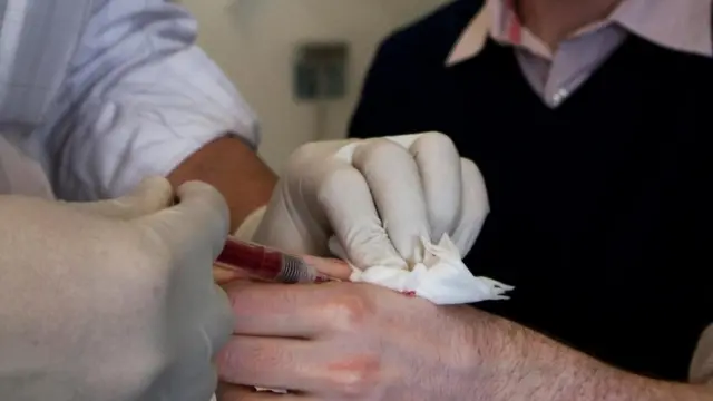 Un doctor implantando el microchip en la mano del doctor Gasson