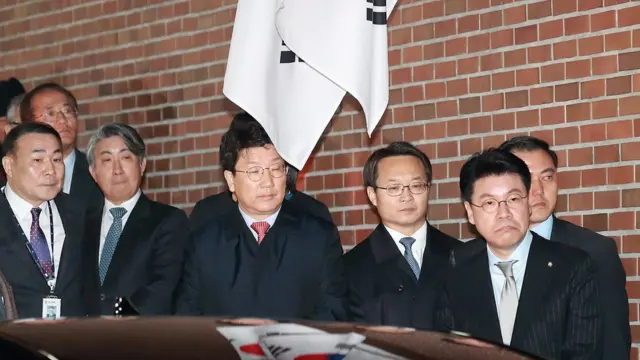 23일 새벽 구치소로 향하는 호송차에 탑승하는 이 전 대통령을 바라보는 측근들